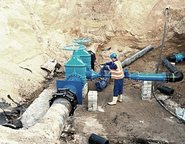 Travailleur souterrain sur vanne, reconstruction du système d'eau potable — Photo