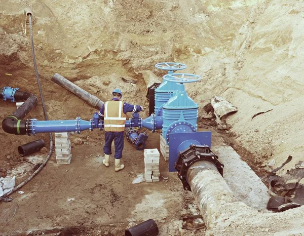 Travailleur souterrain sur vanne, reconstruction du système d'eau potable — Photo