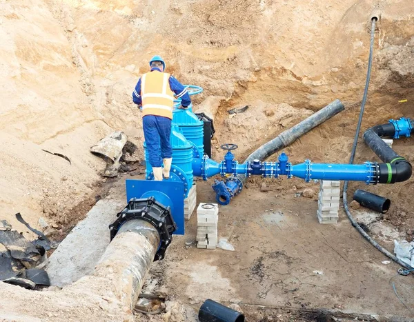 Trabajador subterráneo para reconstruir el sistema de agua potable. Experto técnico en válvula de compuerta — Foto de Stock