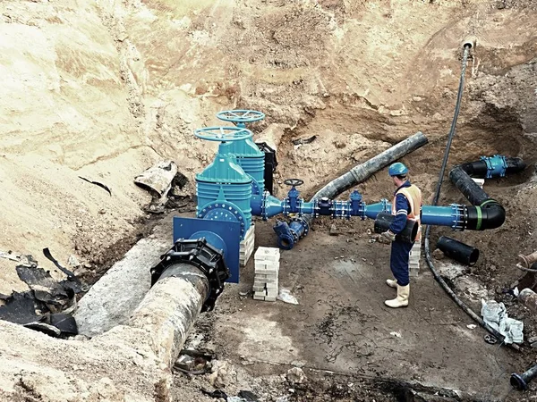 Operaio sotterraneo sulla valvola a saracinesca, ricostruzione del sistema di acqua potabile — Foto Stock