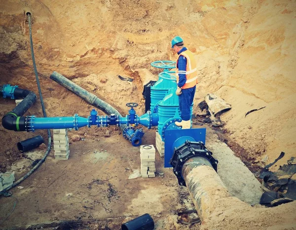 Trabajador subterráneo para reconstruir el sistema de agua potable. Experto técnico en válvula de compuerta — Foto de Stock