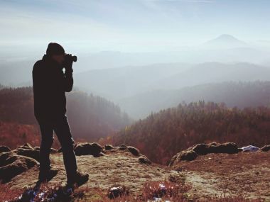 Cliff fotoğrafçı. Doğa fotoğrafçısı tepe üzerinde ayna kamera ile fotoğraf çeker
