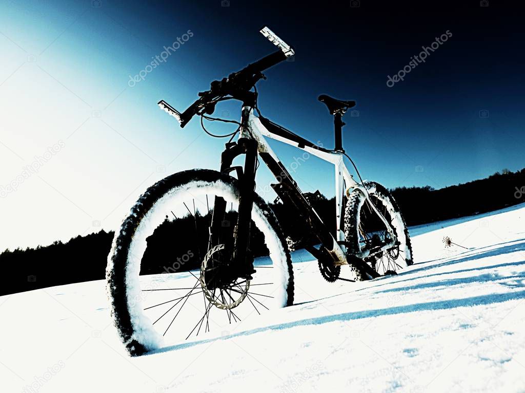 Extremme contrast. Mountain bike stay in powder snow. Lost path  in deep snowdrift. 
