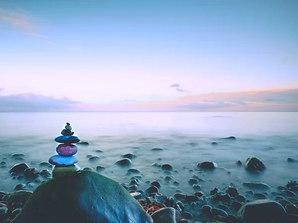 Kerek színes kövek állnak piramis alakú nagy kerek kő a tengeren — Stock Fotó