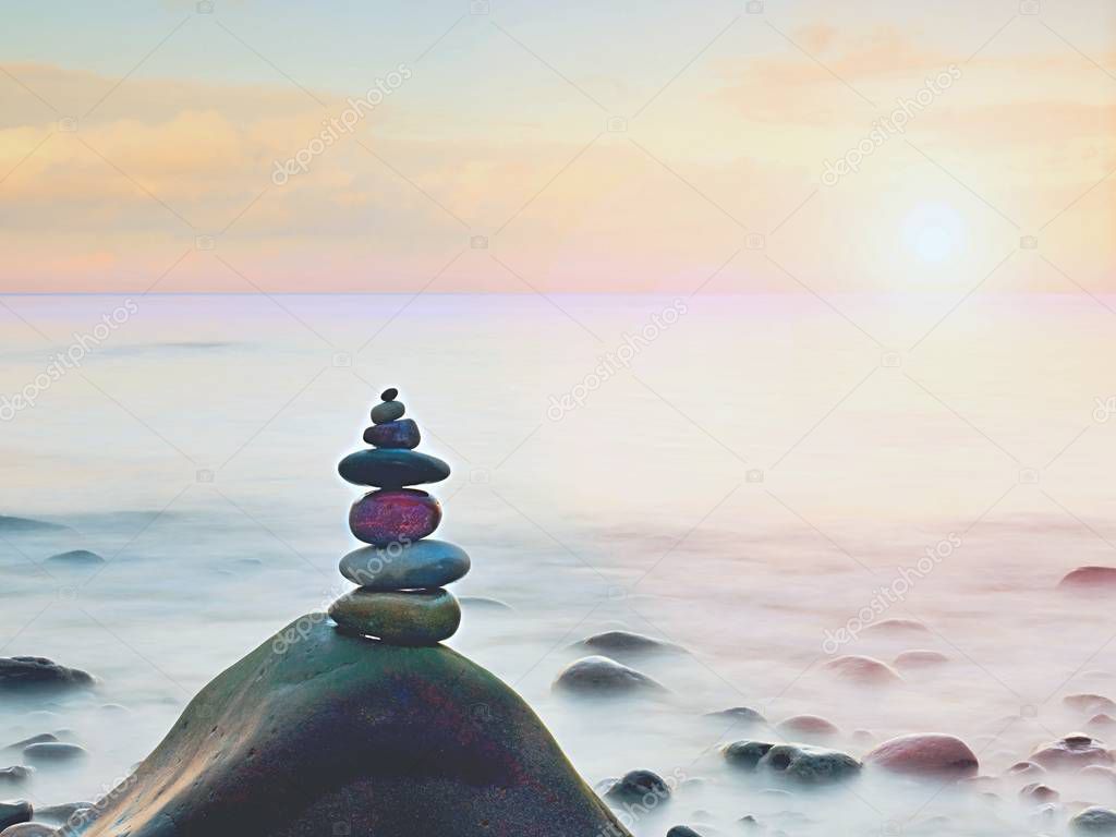 Balance of pebbles against the background of blurred sea.  Smooth atmosphere on beach