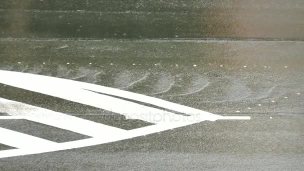 Lluvia fuerte en la carretera de asfalto y el tráfico de automóviles. Tiras blancas sobre asfalto negro. Los cursos de agua rodar por la colina, ruedas de coche salpicar agua.. Día lluvioso en la calle de la ciudad . — Vídeos de Stock