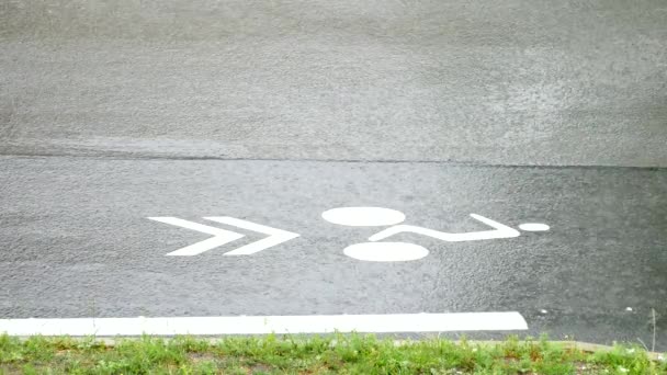 Regn på asfalt road och bil-trafik. Vita remsor på svart asfalt. Vattendrag rulla ner för backen, bil hjul stänk vatten... Regnig dag i gata. — Stockvideo