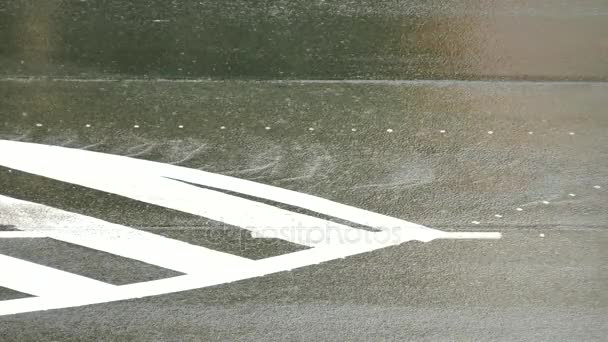 Lluvia fuerte en la carretera de asfalto y el tráfico de automóviles. Tiras blancas sobre asfalto negro. Los cursos de agua rodar por la colina, ruedas de coche salpicar agua.. Día lluvioso en la calle de la ciudad . — Vídeos de Stock