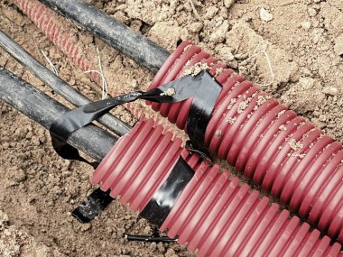 Koruyucu Hdpe boru içinde siyah kablolar ile hendek kazı. Metalik ve fiber optik kablo hatları.