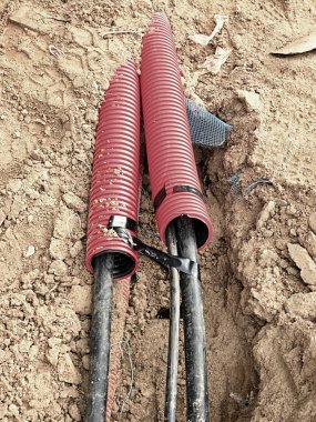Koruyucu Hdpe boru içinde siyah kablolar ile hendek kazı. Metalik ve fiber optik kablo hatları.