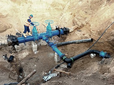Worker underground on gate valve, reconstrucion of drink water system clipart