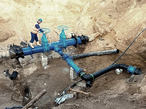 Trabajador subterráneo en válvula de compuerta, reconstrucción del sistema de agua potable — Foto de Stock