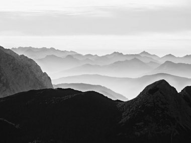 Dağ siluetleri keskin. Uzak dağ silsilesi ve renkli sis ağır bulutlar 