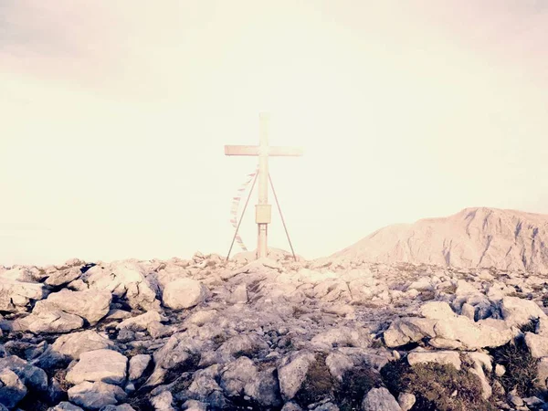 Biddende vlaggen wapperen in de wind over de top Kruis. Houten kruisbeeld bovenop Alpine berg — Stockfoto