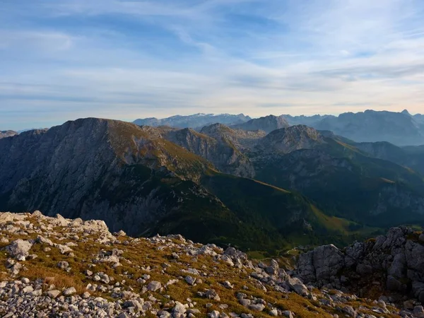 View over Alpine  cliff and valley. Sun at horizon, blue sky with few clouds. Alps mountains — Stock Photo, Image