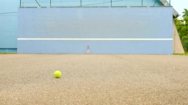 Tenis topu duvara sıçrayan. Tenis topu sahasında çok eski alüminyum tenis raketi duvara yaslansın atlama. 