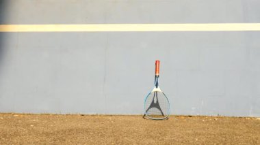 Tenis topu duvara sıçrayan. Tenis topu sahasında çok eski alüminyum tenis raketi duvara yaslansın atlama. 