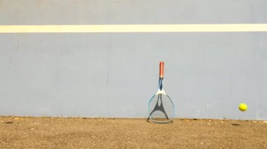 Tenis topu duvara sıçrayan. Tenis topu sahasında çok eski alüminyum tenis raketi duvara yaslansın atlama. 