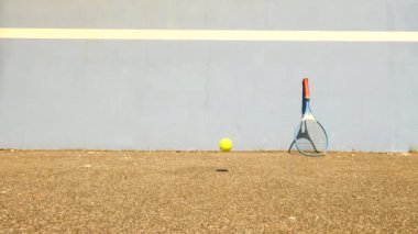 Tenis topu duvara sıçrayan. Tenis topu sahasında çok eski aluminnum tenis raketi duvara yaslansın atlama.