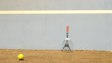 Tenis topu duvara sıçrayan. Tenis topu sahasında çok eski aluminnum tenis raketi duvara yaslansın atlama.