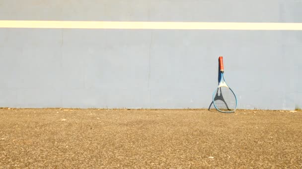 Sehr alter Aluminium-Tennisschläger mit alter Übungstenniswand, gelber Ball auf dem Platz — Stockvideo