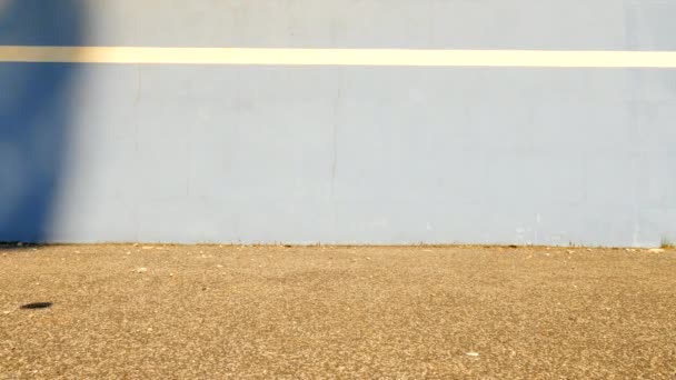 Hüpfender Tennisball gegen Wand. Tennisball springt auf den Platz, sehr alter Aluminium-Tennisschläger lehnt an der Wand. — Stockvideo