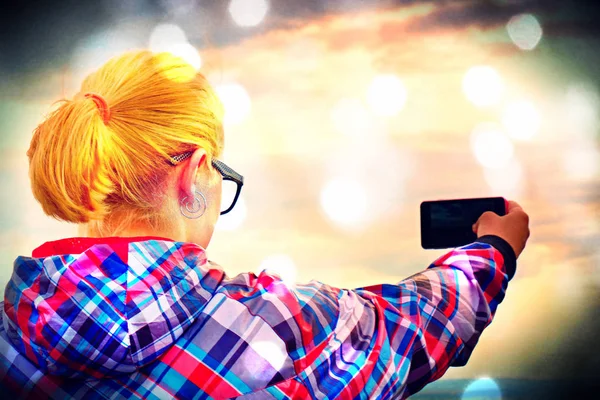 Пленка. Пешая блондинка фотографируется со смартфоном в горах . — стоковое фото
