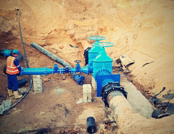 Trabajador subterráneo para reconstruir el sistema de agua potable. Experto técnico en válvula de compuerta — Foto de Stock