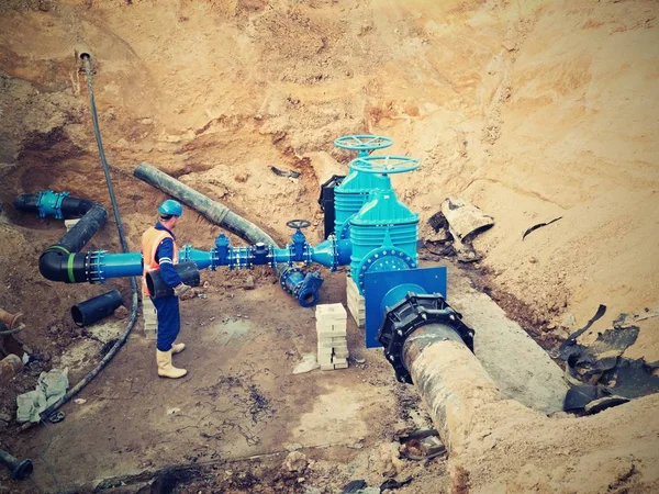 Trabajador subterráneo para reconstruir el sistema de agua potable. Experto técnico en válvula de compuerta — Foto de Stock