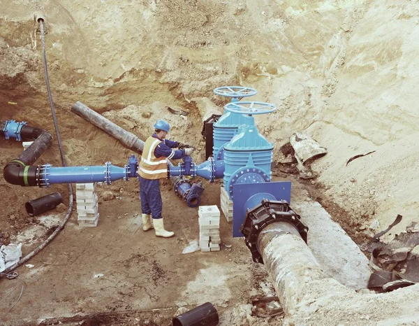 Trabajador subterráneo para reconstruir el sistema de agua potable. Experto técnico en válvula de compuerta — Foto de Stock