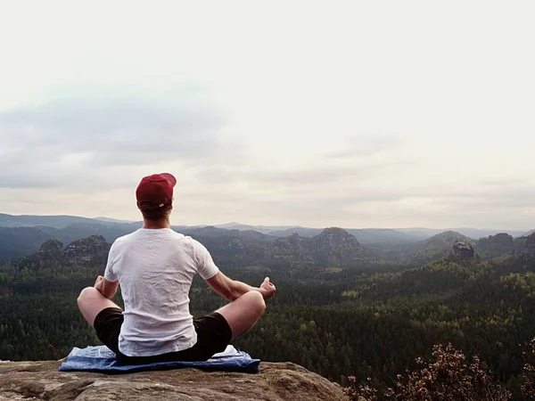 Yoga practicando en cumbre de montaña con vista aérea del valle de montaña. Deportista alto practicando yoga —  Fotos de Stock