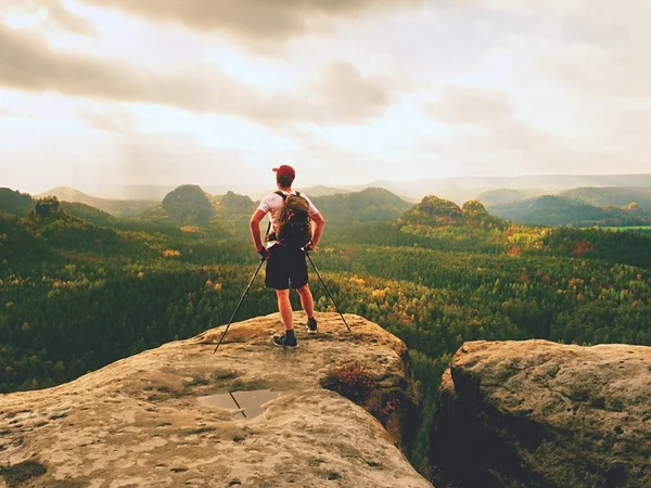 Mann wandert mit Wanderstöcken und Rucksack auf einem Berg. Reisende mit Rucksack — Stockfoto