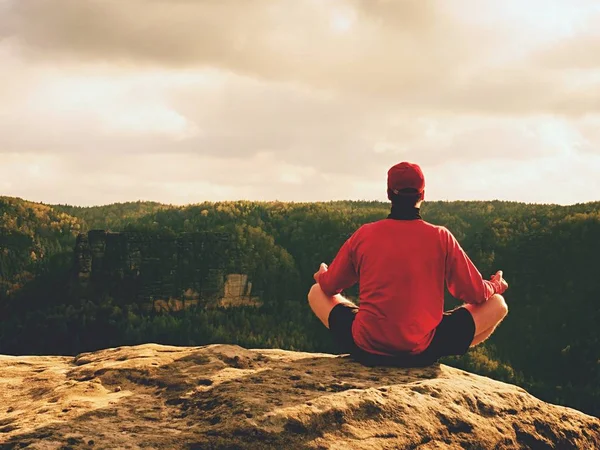Yalnız adam kayalar tepe üzerinde Yoga poz puslu sabah içinde yapıyor. Orta yaşlı adam pratik Yoga