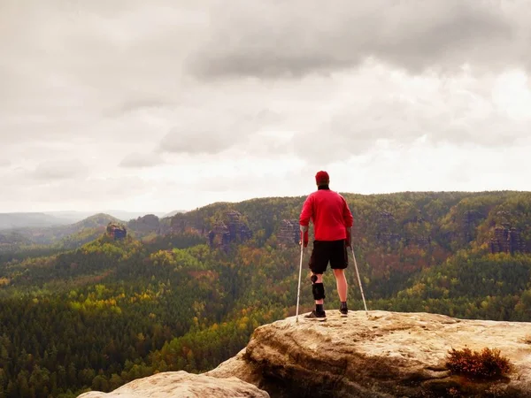 Ön kol koltuk değneği olan adam. Kırık bacak ile elde uzun yürüyüşe çıkan kimse dağ tepe hareketsiz