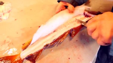 Temizlik ve taze deniz Morina balığı bir aile fabrikasında filleting işçi. Dorsal kesim ve ayırma fileto balık kemikleri, cesaret kaldırma gelen. 
