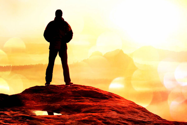 Film grain. Hiker standing on top of a mountain and enjoying sunrise