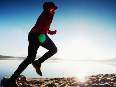 Uzun kumsalda hızlı deniz kıyısında koşan adam uygun. Güçlü runner yaz sabah açık eğitim.