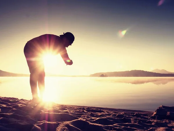 Sports man checking time on his sports watch. Runner at mountain lake exercising — Stock Photo, Image