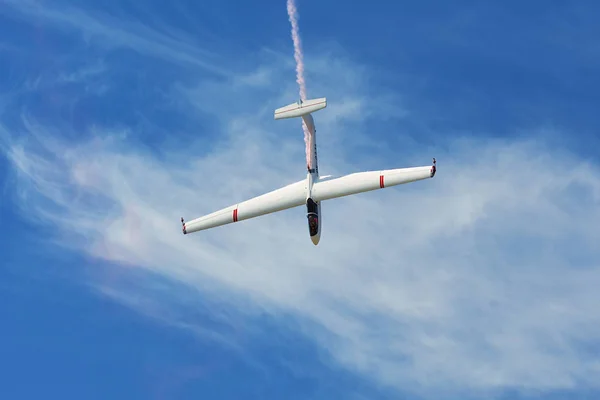 Memorial Airshow. Flying segelflygplan aerobatic team withlight sailplane visar hans prestanda, rök effekt — Stockfoto