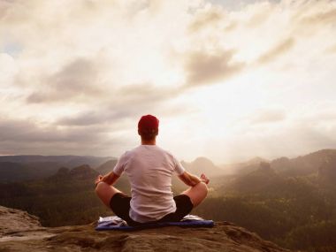 Dağ vadinin hava manzaralı dağ zirvesinde pratiği yoga. Uzun boylu sporcu pratik yoga