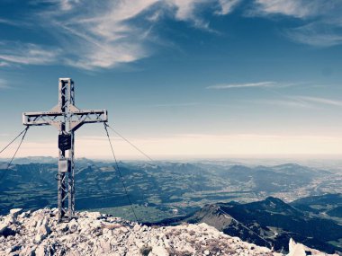 Yüksek kayalık dağ üzerinde çapraz Zirvesi dua. Çelik sanatsal haç Alp dağın zirvesinde