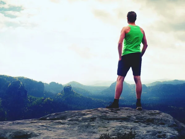 Adam tişört ve pantolon. Turizm peyzaj seyir dağ tepe üzerinde.