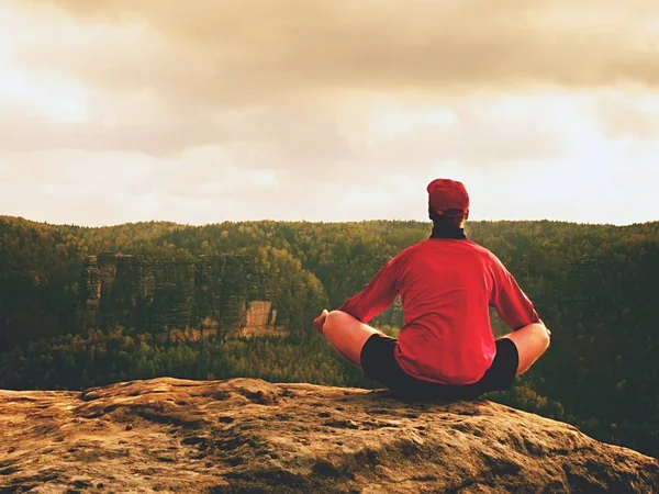 Solo el hombre está haciendo la postura del yoga en el pico de las rocas dentro de la mañana brumosa. Hombre de mediana edad practicando yoga —  Fotos de Stock