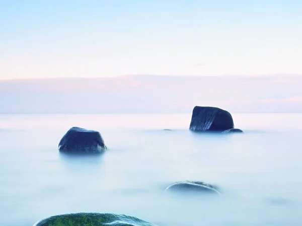 Iedereen houdt van romantische sfeer van zee. Rustige zee niveau, stenen in water — Stockfoto