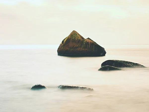 Bizzare rock na praia de seixos, céu dramático acima. Stony offshore . — Fotografia de Stock