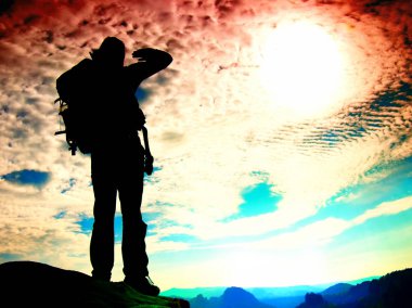 Film tahıl. Turist kayalık bakış ve derin puslu Vadisi feryat izlerken büyük sırt çantası standlı. 