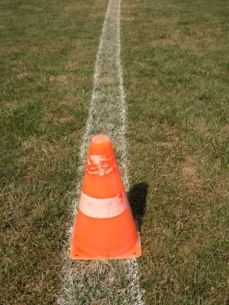 Jasny pomarańczowy biały plastikowy stożek na malowane Biała linia. Bardzo suche boiska do piłki nożnej — Zdjęcie stockowe