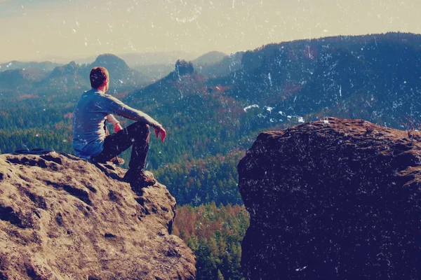 Filmkorn. junger Mann in schwarzer Sportbekleidung sitzt am Feldrand und blickt auf nebliges Tal — Stockfoto
