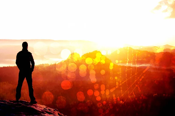 Пленка. Турист стоит на остром углу скалы из песчаника в парке рок-империй и наблюдает за туманной и туманной утренней долиной до Солнца . — стоковое фото
