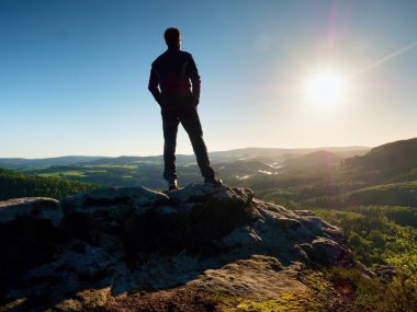 Adam güneş güzel anı Vadisi üzerinden izlerken kumtaşı kaya tepe üzerinde duruyor 